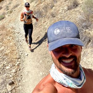 Emily and Joe trail running with Get Better Project hat