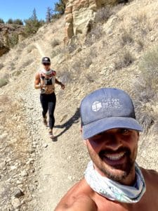 Joe and Emily trail running with Get Better Project hat on