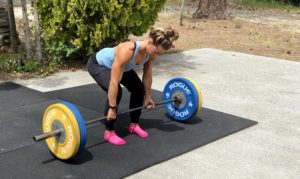 Emily deadlifting with Rogue training bumper plates in driveway